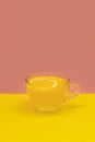 Cup of detox lemon turmeric tea on two colored background