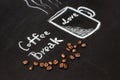 Cup drawn with chalk on black board and real coffee beans Royalty Free Stock Photo