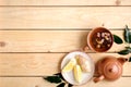 Cup of dried herbal tea, teapot, lemon, plants leaves and ginger root on rustic wooden background, view from above, flat lay Royalty Free Stock Photo