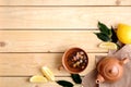 Cup of dried herbal tea, teapot, lemon, plants leaves and ginger root on rustic wooden background, view from above, flat lay Royalty Free Stock Photo