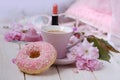 cup with drink coffee cappuccino, hot chocolate with milk, pink donut, lipstick, sakura flowers, caffeine improves functioning of Royalty Free Stock Photo