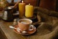 cup with drink coffee on old vintage wooden table, metal coffee maker, candles burn, caffeine improves functioning of human brain Royalty Free Stock Photo