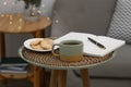 Cup of drink, cookies and notebook on coffee table indoors