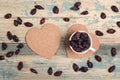 Cup of dry rose hips on a cork coasters-hearts on wooden table