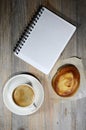 Cup of espresso, checkered notebook and bun