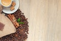 Cup with espresso with coffee beans, burlap sack and cinnamon on light wooden background Royalty Free Stock Photo