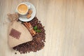 Cup with espresso with coffee beans, burlap sack and cinnamon on light wooden background Royalty Free Stock Photo