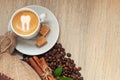 Cup with espresso with coffee beans, burlap sack and cinnamon on light wooden background Royalty Free Stock Photo