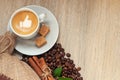 Cup with espresso with coffee beans, burlap sack and cinnamon on light wooden background Royalty Free Stock Photo