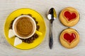 Cup with espresso, coffee beans, sugar in saucer, spoon, cookie with jam heart on table. Top view Royalty Free Stock Photo