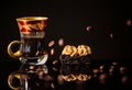 Cup of espresso coffee with chocolate brownie and coffee beans falling from above on reflective black surface Royalty Free Stock Photo