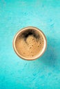 A cup of espresso coffee with froth, overhead flat lay shot on blue Royalty Free Stock Photo