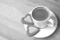 Cup of espresso coffee with a pair of heart shaped cookies on wooden table in monochrome Royalty Free Stock Photo