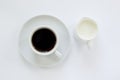 Cup of espresso coffee with saucer and a small pitcher of milk on white background. Top view. Close up image Royalty Free Stock Photo