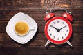 Cup of espresso coffee and vintage clock alarm on wooden table top view Royalty Free Stock Photo