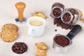 Cup of espresso, crackers, cookies, holder with ground coffee, tamper and cans of coffee beans on table Royalty Free Stock Photo