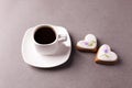 A cup of espresso and a group of cookies with aysing in the shape of a heart on a gray background, conciseness, minimalism.