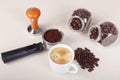 Cup of espresso, holder with ground coffee, tamper and coffee beans on table Royalty Free Stock Photo