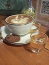 a cup of espresso latte with a piece of chocolate cookies