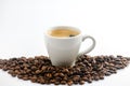 A cup of espresso in a pile of roasted coffee beans on a white background Royalty Free Stock Photo