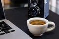 A Cup of Espresso Shot Coffee with a part of laptop keyboard and film camera