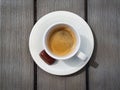 Cup of espresso with small chocolate praline on rustic gray table. Top view