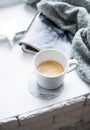 Cup of espresso on white table with cozy interior details Royalty Free Stock Photo