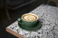 Cup of Flat White coffee in a green cup with beautiful latte art