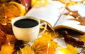 Cup of flavored coffee, book and autumn yellow leaves. Autumn composition. Autumn mood and morning coffee. Close-up