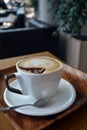 Cup of foamy cappuccino on a wooden table