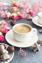 A cup of fragrant coffee in the morning and a bouquet of pink flowers. Chocolate sweets in the form of cockleshells. Shells on the Royalty Free Stock Photo