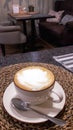 A cup of fresh cappuccino coffee in a cafe