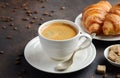 Cup of fresh coffee with croissants on dark background Royalty Free Stock Photo