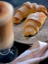 A cup of fresh coffee with croissants on a dark blue background, selective focus Royalty Free Stock Photo