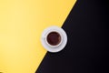 Cup of fresh espresso on yellow and black background, top view with a copy space Royalty Free Stock Photo