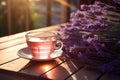 Cup of fresh healthy lavender tea on a wooden table on sunny morning. Lavender tea poured into clear glass cup. Herbal medicine