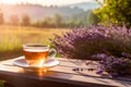 Cup of fresh healthy lavender tea on a wooden table on sunny morning. Lavender tea poured into clear glass cup. Herbal medicine