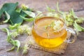 Cup of fresh herbal tea with blooming Tilia linden, basswood