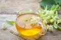 Cup of fresh herbal tea with blooming Tilia linden, basswood