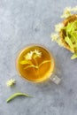 Cup of fresh herbal tea with blooming Tilia linden, basswood