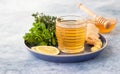 A cup of fresh herbal tea with thyme, mint, ginger, lemon and honey on blue concrete background Royalty Free Stock Photo