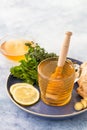 A cup of fresh herbal tea with thyme, mint, ginger, lemon and honey on blue concrete background Royalty Free Stock Photo