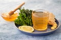 A cup of fresh herbal tea with thyme  mint  ginger  lemon and honey on blue concrete background Royalty Free Stock Photo