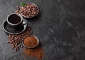 Cup of fresh raw organic coffee with beans and ground powder with coffee tree leaf on black background. Top view Royalty Free Stock Photo