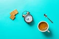 Cup of freshly brewed coffee with crema home baked bran cookies alarm clock spoon on turquoise background. Breakfast morning Royalty Free Stock Photo