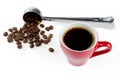 A cup of freshly brewed coffee with foam against the background of a blurry measuring spoon with coffee beans. Royalty Free Stock Photo