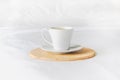 cup of freshly brewed coffee stands on wooden tray on clean white bed. mate cups with morning coffee