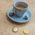 A cup of freshly-drunk espresso with the cost in Italy alongside. coffee is a global busines