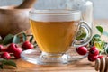 A cup of freshly prepared rosehip tea on a wooden table Royalty Free Stock Photo