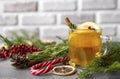 Cup fruit tea with Apple and lemon, cinnamon, spruce branches, rosemary, Lollipop, red berries on a gray background Royalty Free Stock Photo